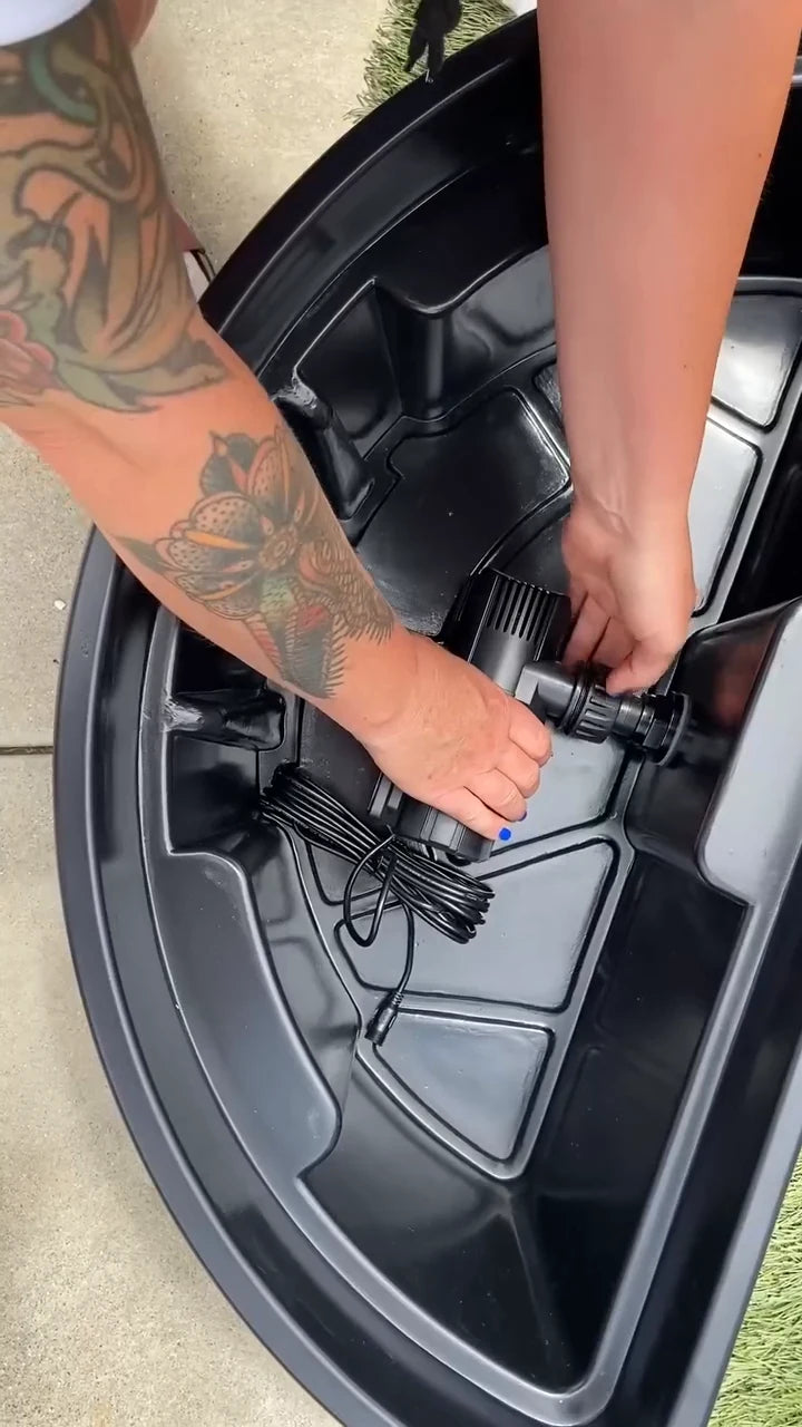 The creator connects the pump inside the open black reservoir before covering it.